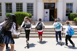 Back view shot of students running to their classroom